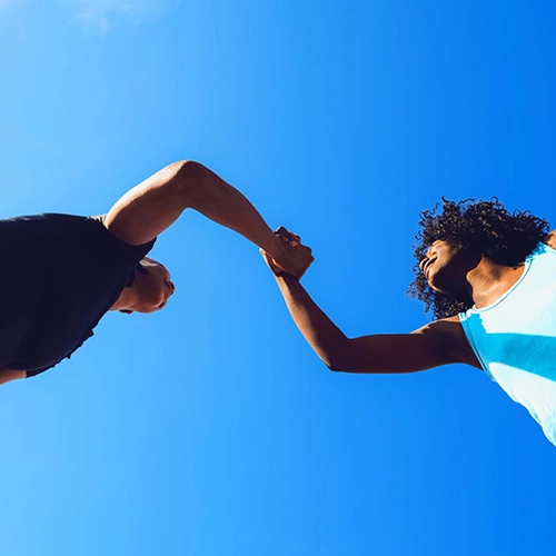 Mann und Frau in Sportkleidung vor blauem Hintergrund.