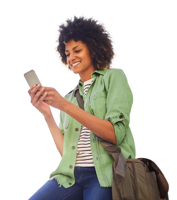 Frau in Freizeitkleidung sitzt halb und schaut lächelnd auf ihr Handy.